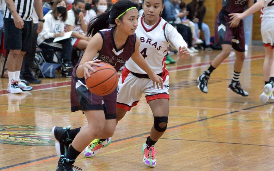 Matthew C. Perry's Aiya Versoza dribbles against E.J. King's Miu Best during Friday's DODEA-Japan girls basketball game. The Cobras won 58-10.