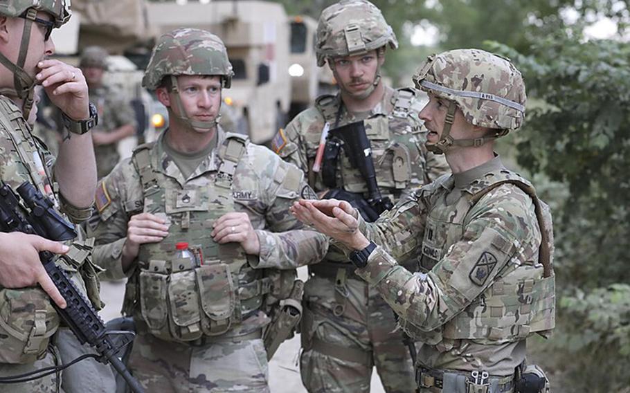 A soldier speaks to others during an exercise. 