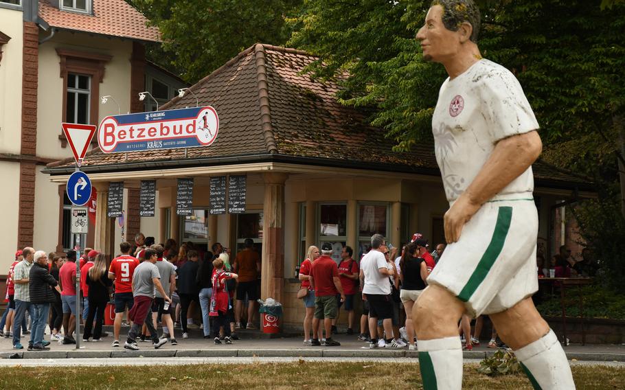FC Kaiserslautern supporters convene at the Betzebud food stand ahead of a Sunday afternoon soccer game, Sunday, Aug. 28, 2022. The stand is near the Football Without Borders statue project, which was erected in 2006 to correspond with the World Cup. 