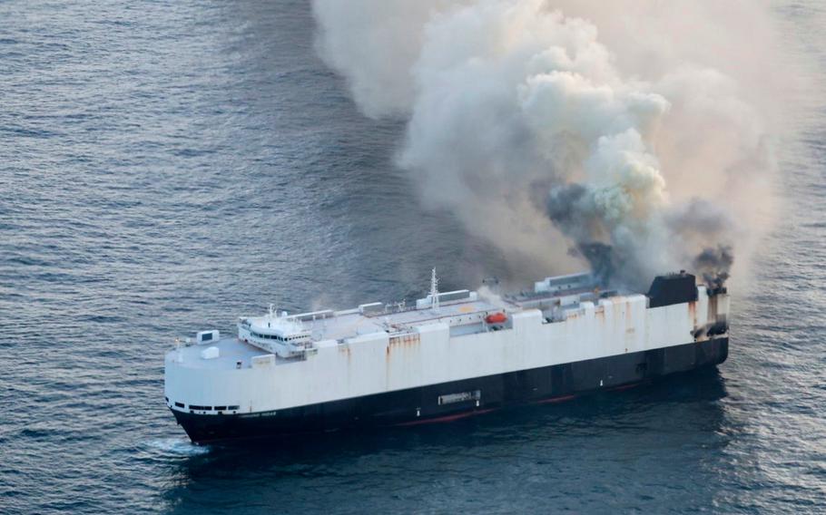 Smoke rises from a ship at sea.