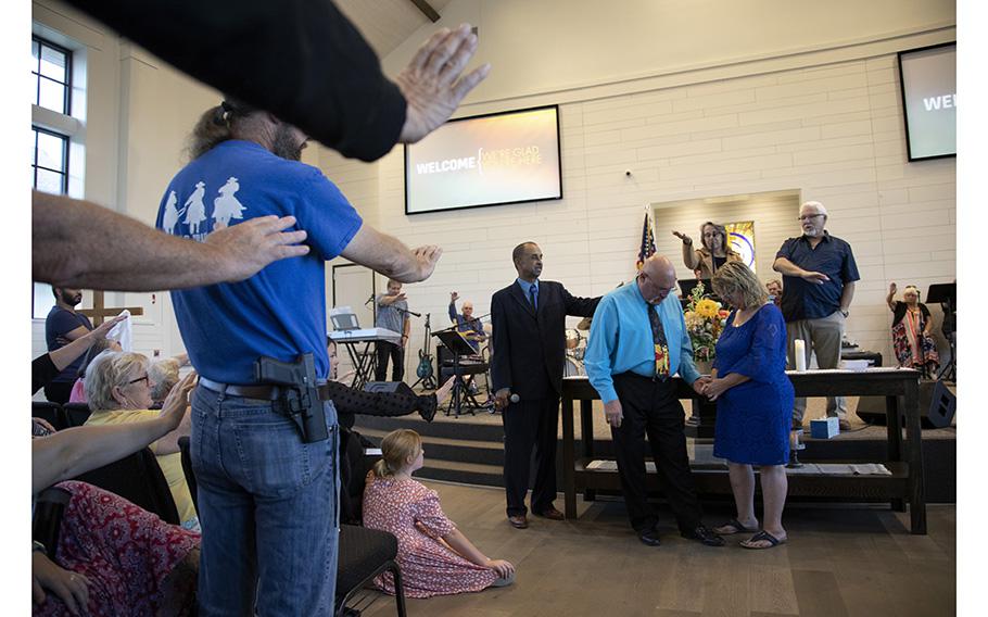 The congregation at First Baptist Church of Sutherland Springs prays over Frank Pomeroy and his wife, Sherri Pomeroy, during Frank’s last service as pastor, on Sept. 25, 2022.