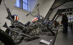 Visitors look at vintage Harley-Davidson models at the German Motorcycle Museum in Neckarsulm, Germany, Jan. 21, 2024. The museum also features this 1987 replica model with a Stars and Stripes tank design, paying homage to the custom chopper ridden by Peter Fonda in the iconic 1969 movie "Easy Rider."