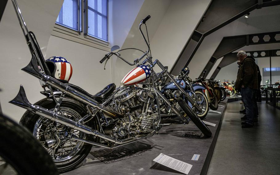 Visitors look at vintage Harley-Davidson models at the German Motorcycle Museum in Neckarsulm, Germany, Jan. 21, 2024. The museum also features this 1987 replica model with a Stars and Stripes tank design, paying homage to the custom chopper ridden by Peter Fonda in the iconic 1969 movie “Easy Rider.”