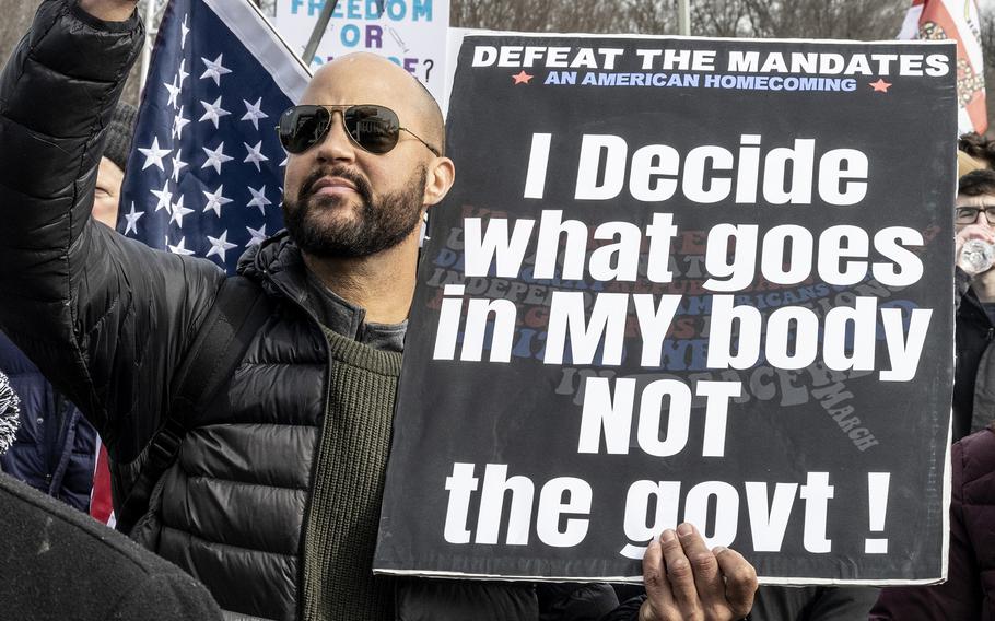 A man opposed to COVID vaccination mandates holds a sign on the steps of the Lincoln Memorial in Washington, D.C., Jan. 23, 2022.