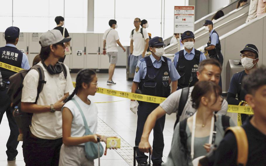 Japanese police officers patrol a train station after a man was arrested at the station in Izumisano, south of Osaka, western Japan, Monday, July 24, 2023, following an emergency call of a knife attack on a train. Japanese police said Monday that they have arrested a man on suspicion of slashing multiple people on a train in western Japan. 