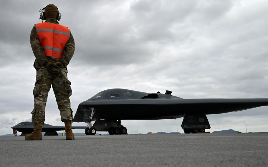 A 393rd Expeditionary Bomb Squadron crew chief marshals a B-2 Spirit in Keflavik, Iceland, on Aug. 15, 2023. Stealth bomber crews are participating a bomber task force mission.