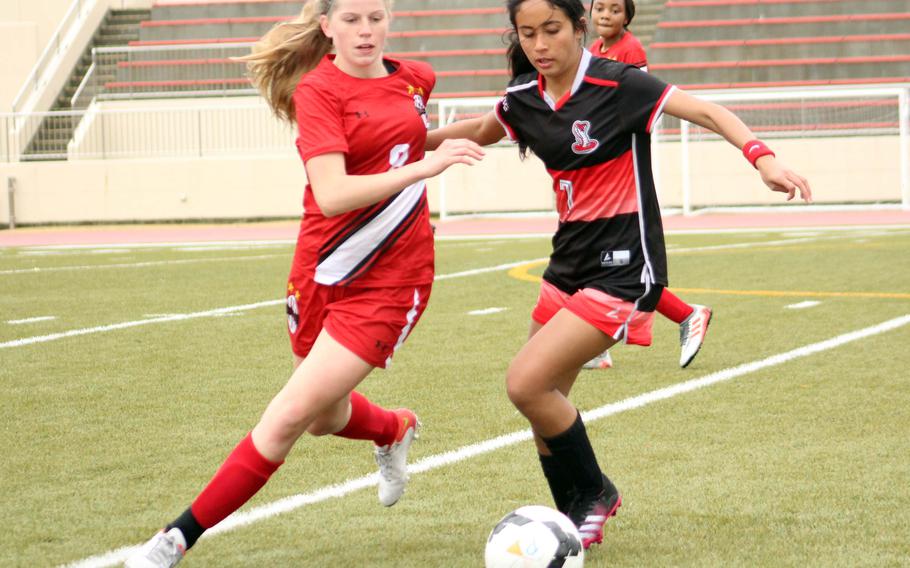 Nile C. Kinnick's Bree Withers and E.J. King's Fernanda Diaz chase down the ball during Friday's DODEA-Japan soccer match. The teams battled to a 1-1 draw.