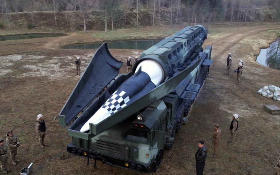 North Korean leader Kim Jong Un, in all black, stands in front of an intermediate-range ballistic missile, April 2, 2024, in this image from the Korean Central News Agency.