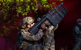 An Air Force security forces member aims a DroneDefender at a small drone during an exercise at East Range Training Area, Hawaii, Feb. 11, 2025. The Defense Department's new Task Force 401 aims to speed up the provision of tools for personnel to deal with small drones.