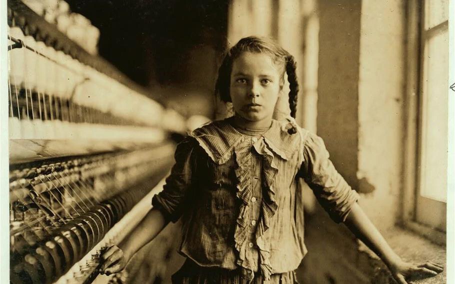 A young spinner in a North Carolina cotton manufacturing company poses for Lewis Hine, the documentary photographer who inspired the creation of laws to ban child labor.