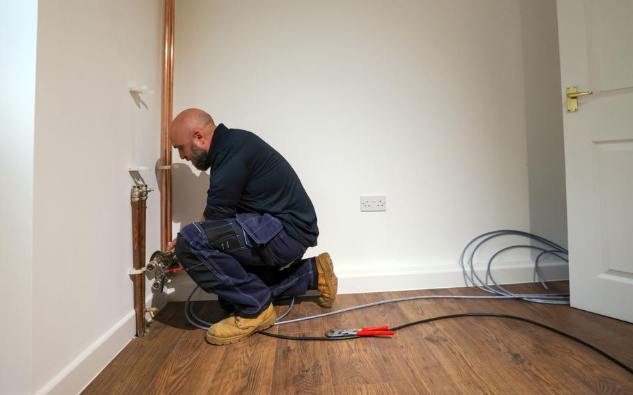 An engineer works on pipe installation inside a training house with an external heat pump at the Octopus Energy Ltd.’s training and R&D centre in Slough, U.K., on Sept. 28, 2021. 