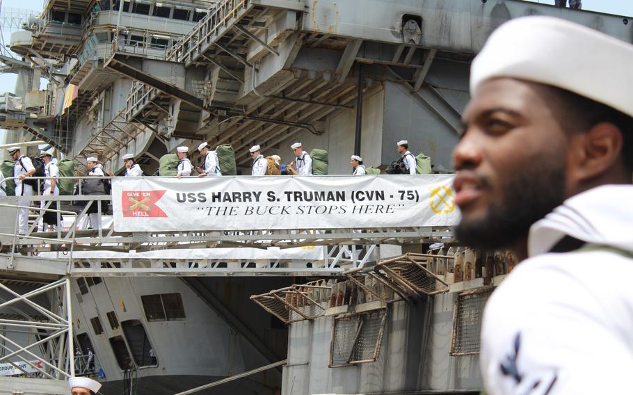 Sailors walk off the USS Truman