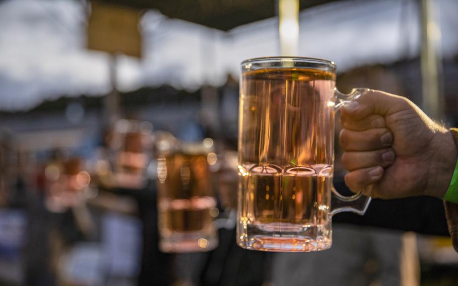 A hand holds a glass of beer.