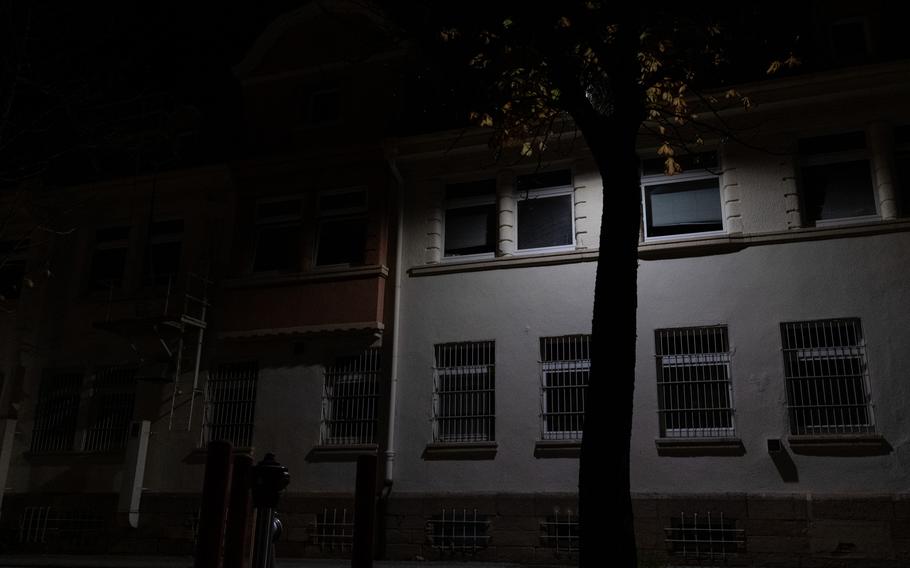 A building at Kleber Kaserne in Kaiserslautern, Germany, is illuminated by a single light Wednesday, Oct. 26, 2022. New Army measures to conserve energy at European bases call for heating caps and disuse of outdoor lighting that offers little security or safety. 