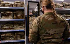 Senior Airman Quynn Santjer looks through the maternity options at Military Clothing Sales at Langley Air Force Base, Va., in December 2021. The Air Force plans to start loaning maternity uniforms to pregnant airmen and guardians at select bases around Oct. 1.