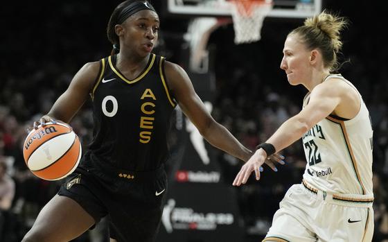 Las Vegas Aces guard Jackie Young (0) drives against New York Liberty guard Courtney Vandersloot (22) during the second half in Game 1 of a WNBA basketball final playoff series Sunday, Oct. 8, 2023, in Las Vegas. (AP Photo/John Locher)