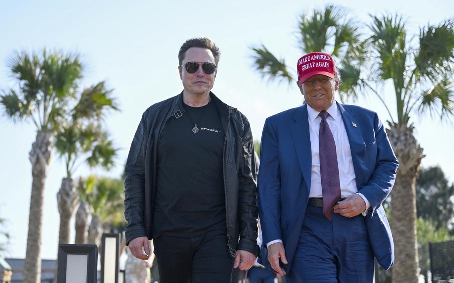 Elon Musk and Donald Trump, wearing a Make America Great Again cap, walk together in in Boca Chica, Texas. 