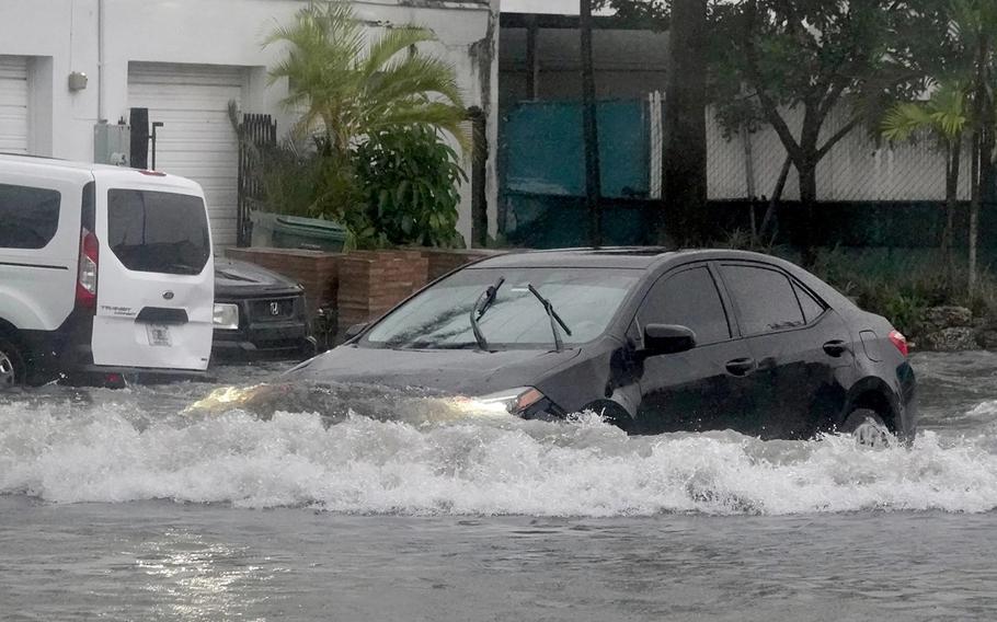 A car makes its way through a flooded street in Oakland Park on Wednesday, Nov. 15, 2023. 