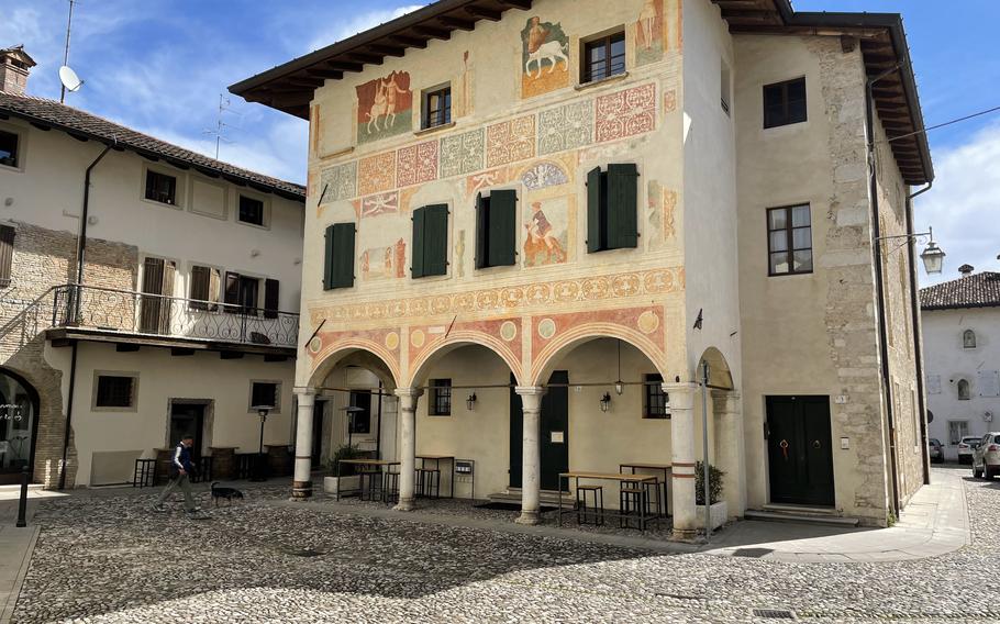 A man walks his dog past the Palazzo Ercole, also known as the Painted House, just outside of the Spilimbergo city center, April 17, 2024. The frescoes depict The Abduction of Deianira; Chiron the centaur; the Spilimbergo lineage; two scenes with children and Hercules wrestling the lion.