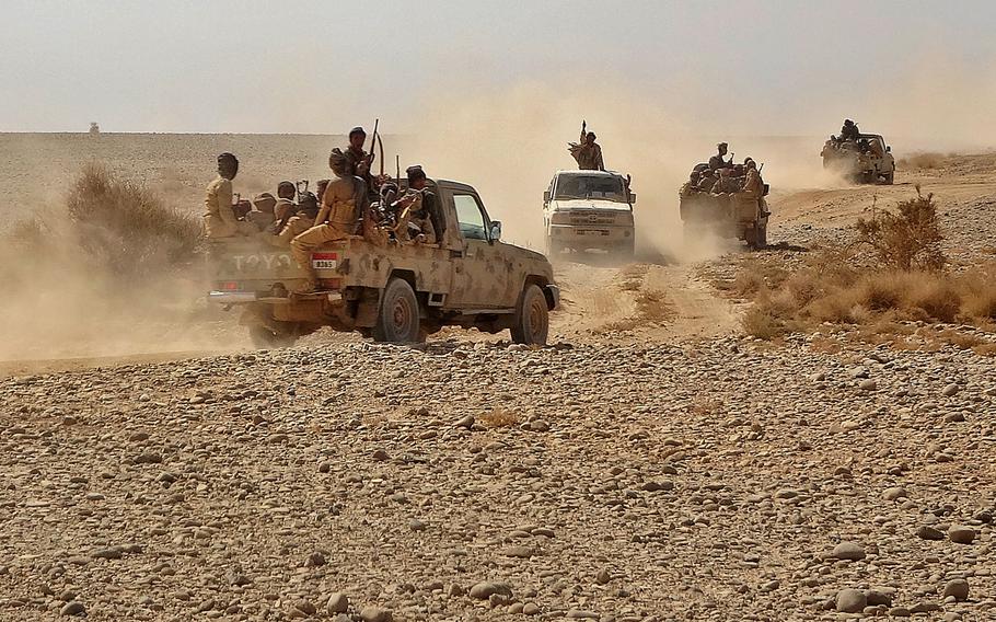 Fighters ride in pickup trucks as forces loyal to Yemen’s Saudi-backed government clash with Houthi rebel fighters around the strategic government-held “Mas Camp” military base. 