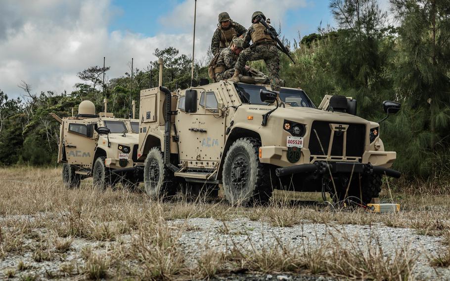U.S. Marines set up a communications receiver on a joint light tactical vehicle during a field exercise on the Japanese island of Okinawa on Feb. 7, 2023. The JLTV is an Army-led joint program with the Marine Corps designed to close capability gaps in the light tactical vehicle fleets.