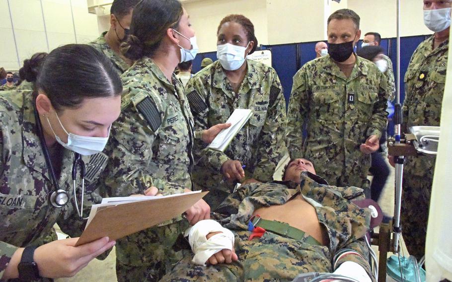 From left, Navy hospital corpsman Grace Sloan, registered nurse Lt. Jennifer Perez, physician assistant 
Lt. Rasheda Dia, registered nurse Lt. Shawn Holdsworth, and Lt. Cmdr. Louis Grass, a certified registered nurse anesthetist, all of Camp Pendleton, Calif., confer over a simulated casualty at Camp Foster, Okinawa, on Nov. 15, 2022.  