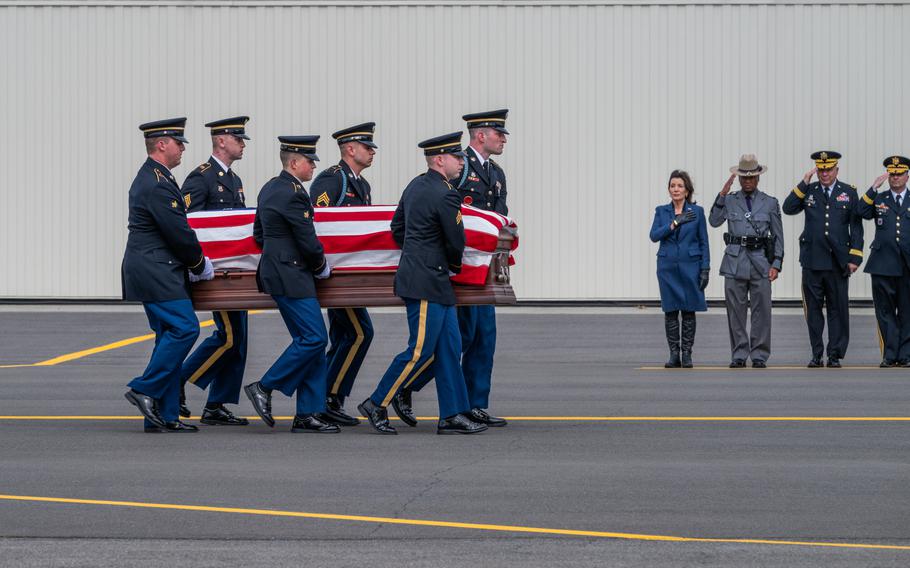 A New York Army National Guard Honor Guard team carries the remains of Chief Warrant Officer John M. Grassia III from a New York Air National Guard LC-130 to a hearse past a line of dignitaries, including Gov. Kathy Hochul, during planeside honors conducted at the Army Aviation Support Facility in Latham, N.Y., on Monday, March 18, 2024. 