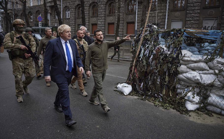 Ukrainian President Volodymyr Zelenskyy, center, and Britain’s Prime Minister Boris Johnson, center left, walk in downtown Kyiv, Ukraine, on April 9, 2022. 