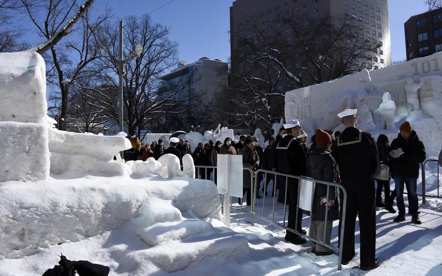 Sailors from Naval Air Facility Misawa pose for photos near their snow carrier at the Sapporo Snow Festival in Hokkaido, Japan, Feb. 5, 2024. 