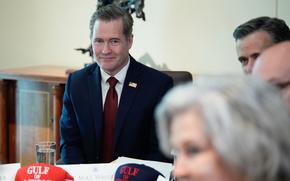Four people at a table, Mike Waltz in being the only one in focus.