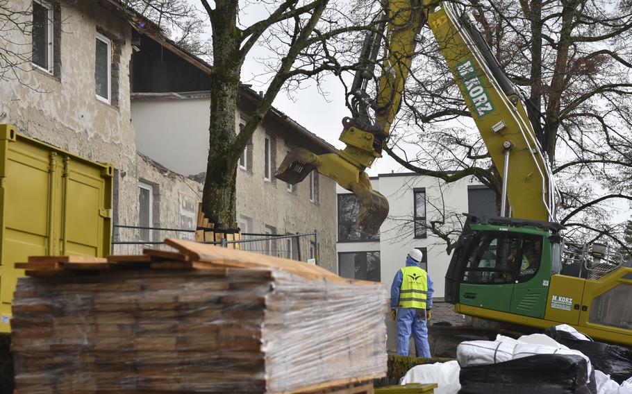 Workers position an excavator to demolish a building section in the Army's Crestview neighborhood in Wiesbaden, Germany, on March 11, 2024.