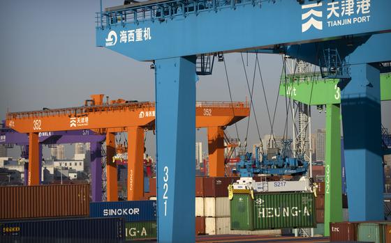 File - A crane lifts a shipping container at an automated container port in Tianjin, China, Jan. 16, 2023. The global economy, which has proved surprisingly resilient this year, is expected to falter next year under the strain of wars, still-elevated inflation and continued high interest rates. (AP Photo/Mark Schiefelbein, File)