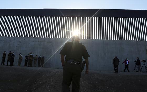 A U.S. Border Patrol agent walk up to a new section of the border wall before the arrival of Acting Homeland Secretary Chad Wolf Thursday, Oct. 29, 2020, in McAllen, Texas. An investigation is underway after a Texas National Guard soldier allegedly shot and wounded a migrant during a struggle on the U.S-Mexico border this month. The quiet handling of the incident has drawn criticism from a Texas lawmaker and a former head of U.S. Customs and Border Protection. (Joel Martinez/The Monitor via AP)