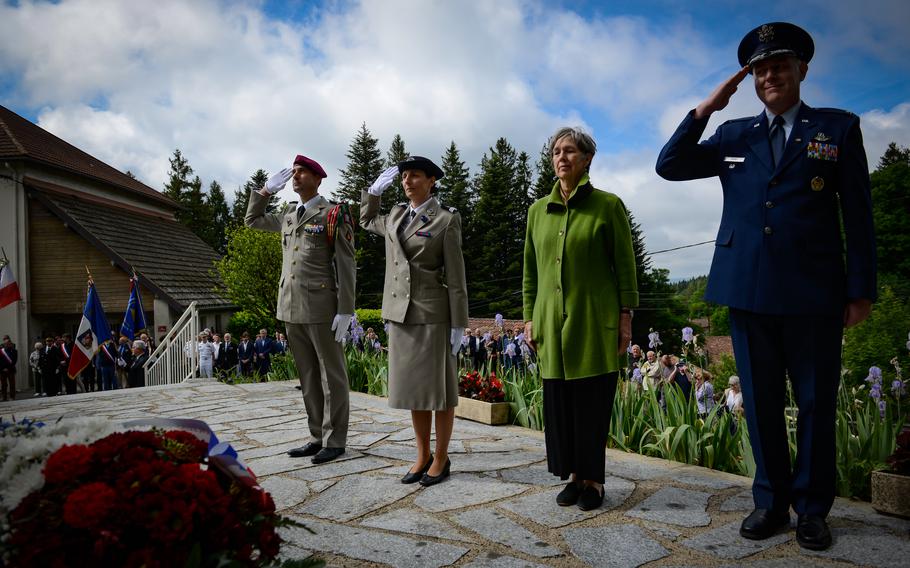From left, retired French Adjudant Cyril Pefaure, Sergent-Cecile Girardi, Meredith Wheeler and retired U.S. Air Force Col. Pierre Oury stand and salute for a moment of silence at a memorial for fallen U.S. soldiers and French resistance troops killed during World War II in Le Rialet, France, May 28, 2022. 