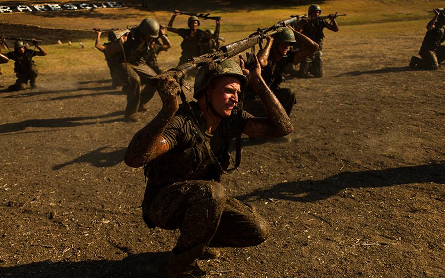 Airmen duck walk with their weapons during the Air Force pararescuemen indoctrination "Hell Week" course at Lackland Air Force Base, Texas, Sept. 6, 2011. The duck walk is an exercise every military recruit completes during the physical evaluation at military entrance processing stations.