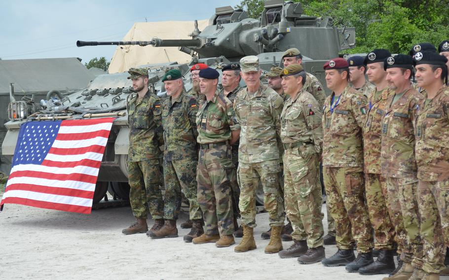 Gen. James McConville, Army chief of staff, looking right, stands with Maj. Gen. James Martin, commander of the British 3rd Division, and troops from Great Britain, Germany, Italy and France during a multination training exercise Thursday, April 20, 2023, at Fort Hood, Texas.