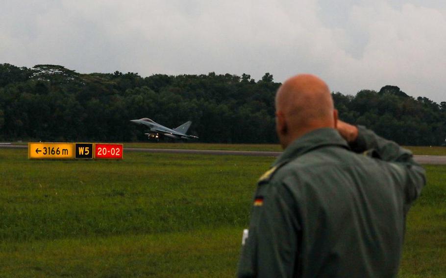 A German air force officer salutes the first arriving German Eurofighter jet in Singapore, Aug. 16, 2022.