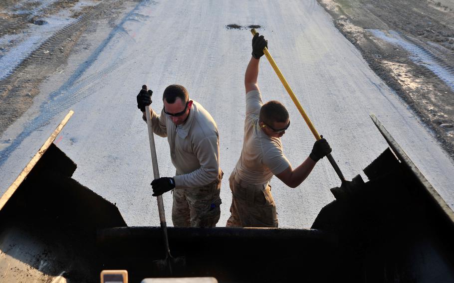 Airmen assigned to the 557th “Red Horse” squadron shovel asphalt at Bagram Air Field, Afghanistan, in 2014. The unit was deactivated in a ceremony at Al Udeid Air Base, Qatar, on Oct. 15, 2022.