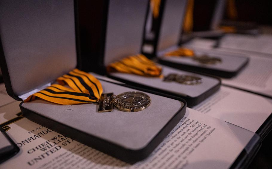 Medals bearing the Special Operations Command insignia rest in cases. 