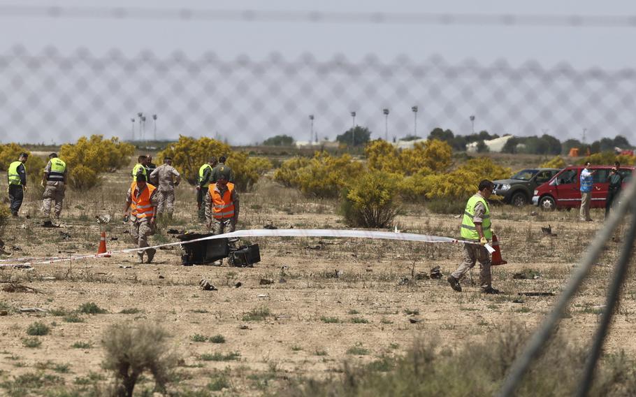 Emergency service members work in the area where an F-18 fighter jet crashed in Zaragoza, Spain, Saturday, May 20, 2023. An F-18 fighter jet crashed at an airbase in the Spanish city of Zaragoza but the pilot ejected successfully, the Spanish defense ministry said Saturday. The aircraft landed within the perimeter of the base, the defense ministry said on Twitter. 