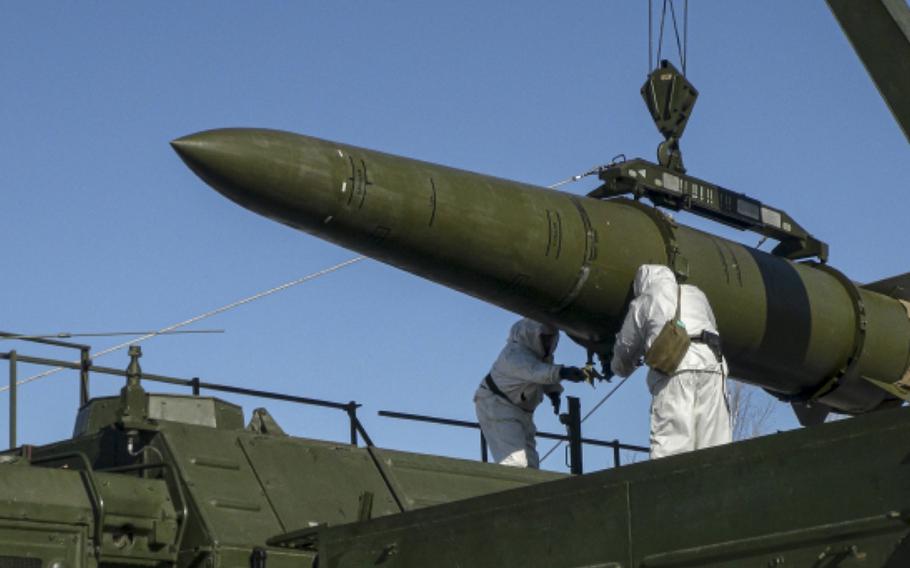Russian troops load an Iskander missile onto a mobile launcher during drills at an undisclosed location in Russia. 