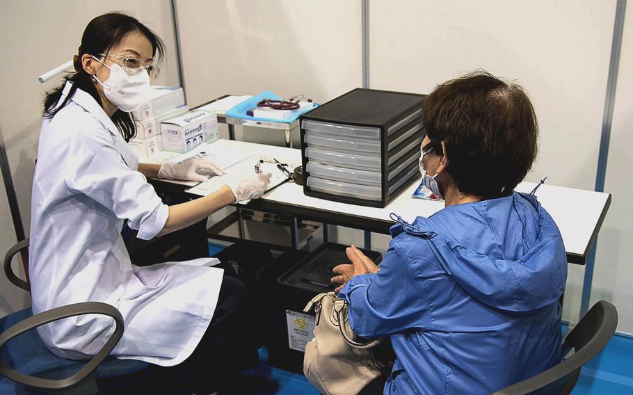 A woman checks in at a COVID-19 vaccination site in Yokohama, Japan, May 17, 2021.