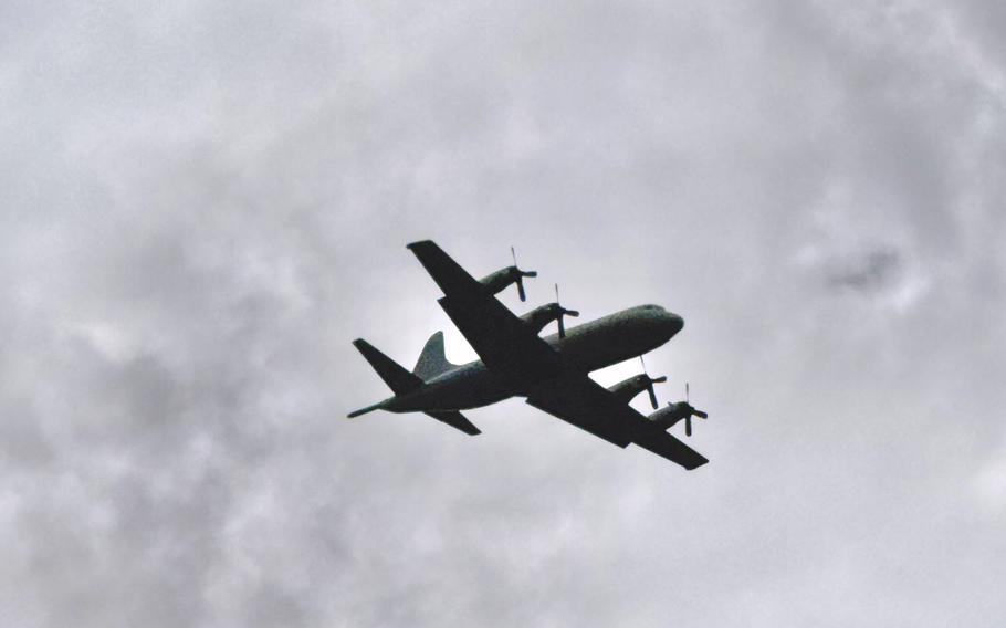 A Taiwan air force C-130 flies overhead.