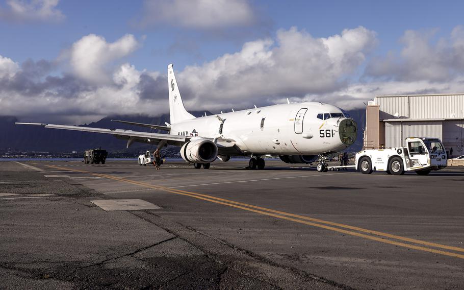 U.S. Navy Sailors tow a U.S. Navy P-8A Poseidon to a designated wash area after extraction from waters just off the runway at Marine Corps Air Station Kaneohe Bay, Marine Corps Base Hawaii, Dec. 4, 2023. The aircraft was relocated in preparation for decontamination of any potential foreign substances as well as salt water from its exterior.