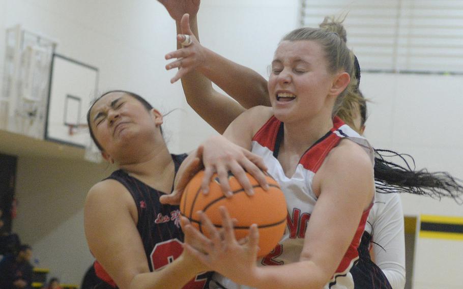 Gimme that ball! Nile C. Kinnick's Leona Turner and E.J. King's Madylyn O'Neill grapple for the ball during Saturday's third-place game in the 5th American School In Japan Kanto Classic basletball tournament. The Red Devils outlasted the Cobras 51-45.