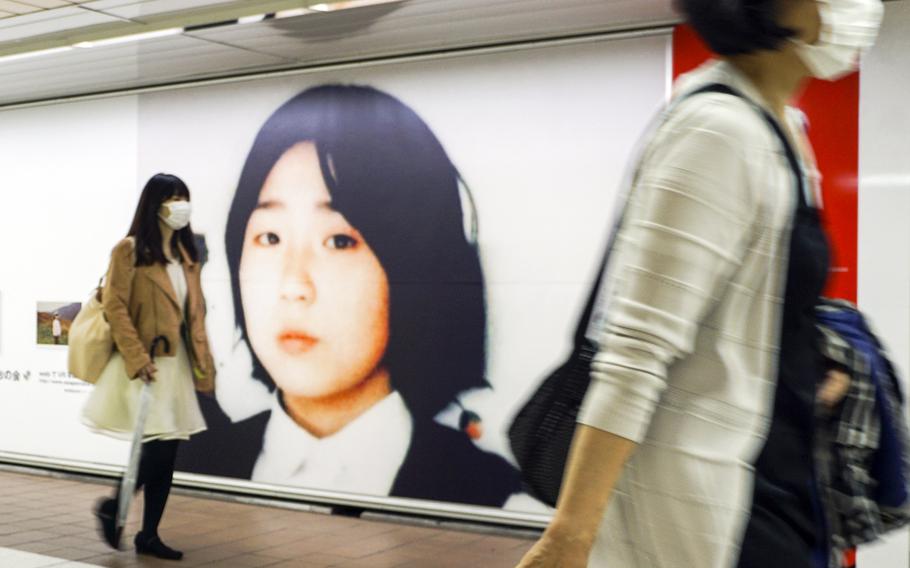 Commuters walk past photos of Megumi Yokota, who was abducted by North Koreans in 1977, at Shinjuku Station in Tokyo, May 9, 2018.