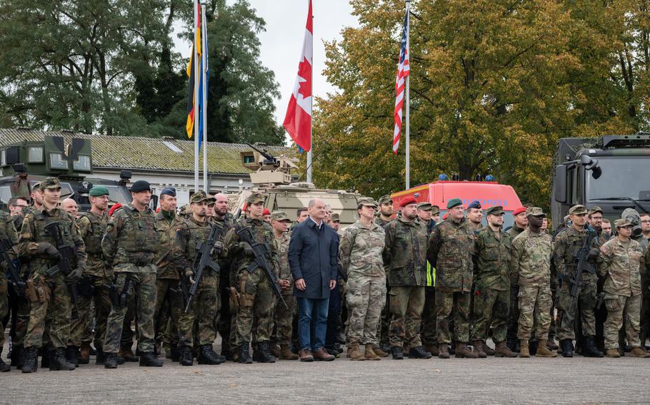 German Chancellor Olaf Scholz poses with German and American troops at a military base outside Cologne, Germany, Oct. 23, 2023.