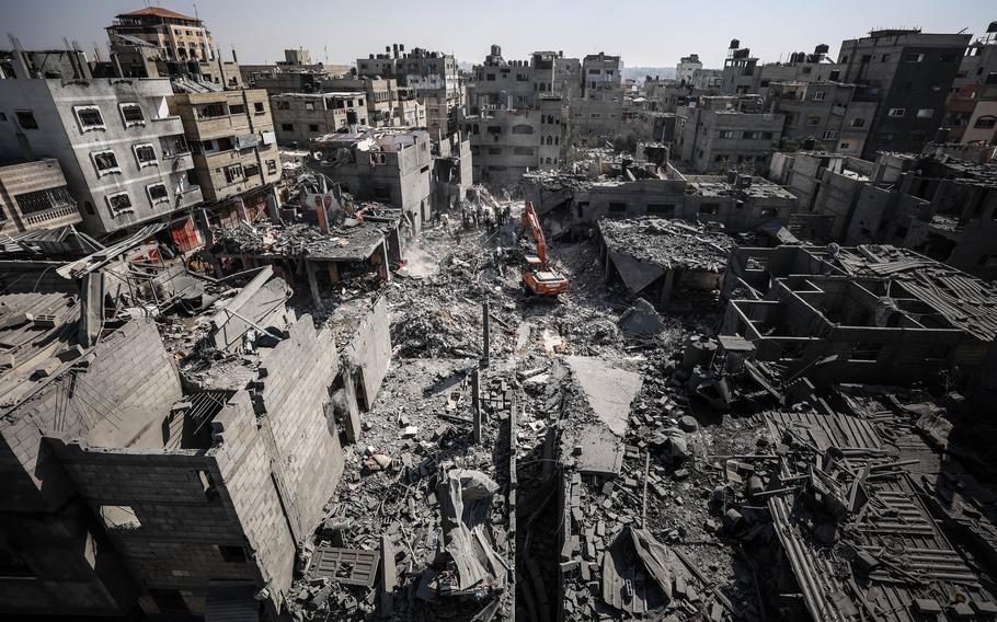 Palestinians survey the damage caused by an airstrike to a home in downtown Khan Younis in the Gaza Strip on Wednesday, Oct. 25, 2023.