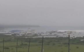 An image taken from a video shows water flooding buildings along a coast.
