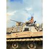 A shirtless man atop a tank.